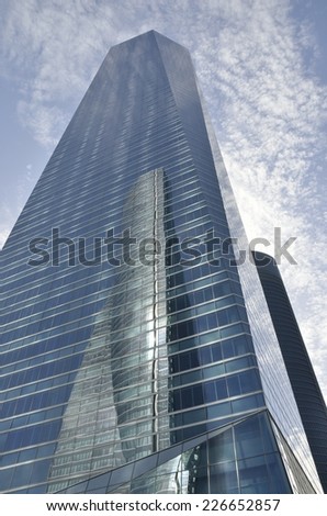 MADRID, SPAIN - OCTOBER, 18: Reflection of the Space Tower into the Crystal Tower on October 18, 2014 in Madrid, Spain.   The Crystal tower was designed by Pelli and the Space tower by  Henry N. Cobb.