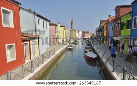 BURANO, ITALY - AUGUST 10: Colorful houses along a canal on August 10, 2014 in Burano, an island of Venice, Italy