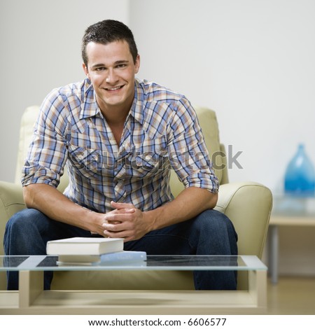 Portrait of young man sitting in chair smiling