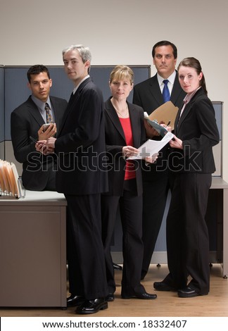 Group of co-workers meeting and working in cubicle