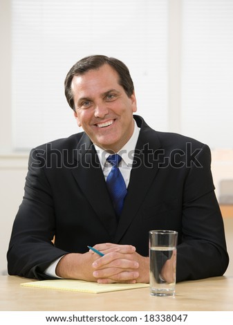 Confident businessman with pen and legal pad