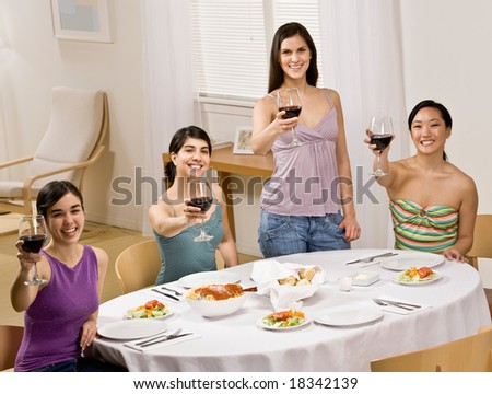 Friends toasting with red wine at dinner party