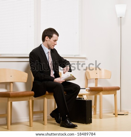 Businessman anxiously waiting for appointment or interview in office waiting area