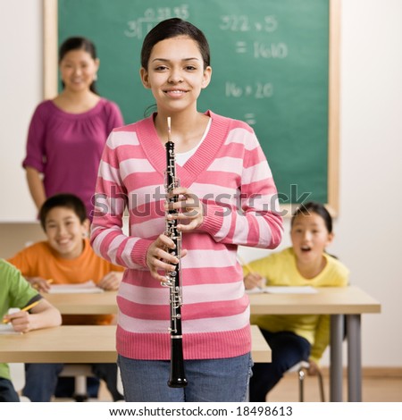 Confident musician holds clarinet in school classroom