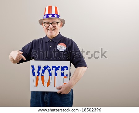 Patriotic man in American flag hat and vote button pointing to vote sign