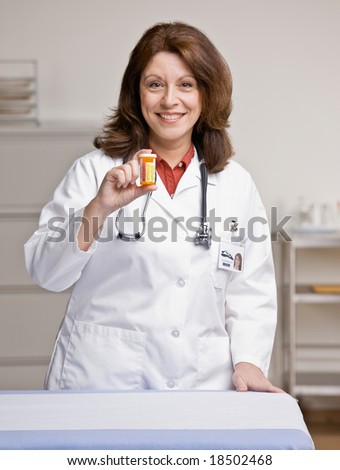 Doctor in lab coat holding prescription medication bottle