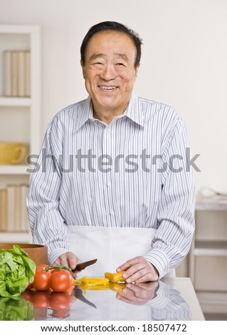 Helpful man preparing wholesome salad in kitchen for dinner