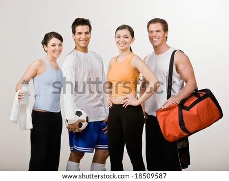 Soccer player and athletic friends in sportswear with soccer ball, gym bag and water bottle
