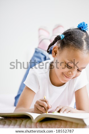 Happy girl coloring in coloring book