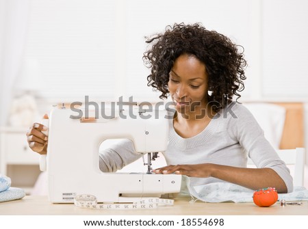 Creative woman using sewing machine to sew clothing