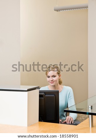 Receptionist working on computer at front desk