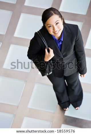 High angle view of happy businesswoman in full suit standing with purse