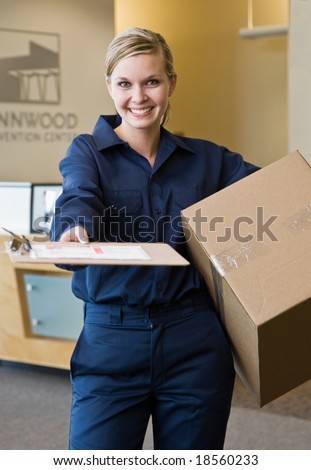 Friendly delivery woman in uniform presenting shipping receipt and holding cardboard box