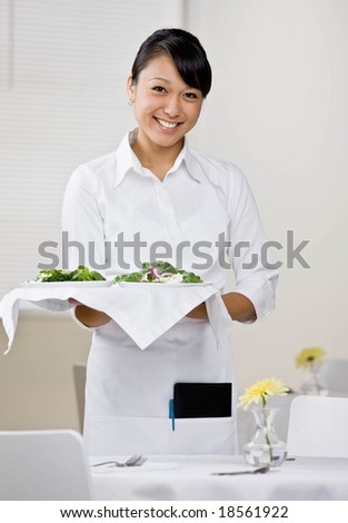 Happy waitress serving healthy salad for lunch in elegant restaurant