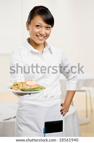 Happy waitress serving healthy dinner of salmon and asparagus