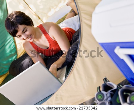 Woman using laptop in tent