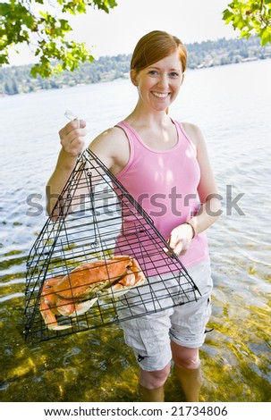Woman holding crab in trap
