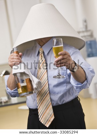 stock photo : Male wearing lampshade on his head, holding Champagne bottle and glass in hands. Vertical