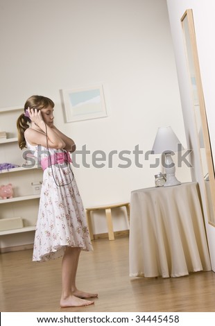 A young girl listening to music with headphones.  Vertically framed shot.