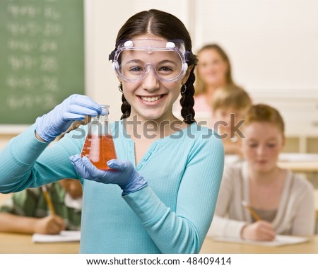 Student holding beaker of liquid in classroom