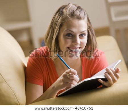 Teenage girl writing in book