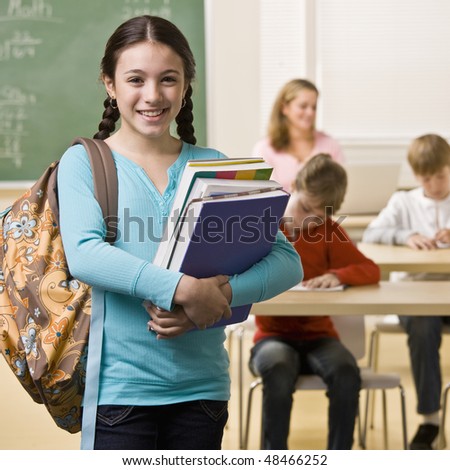Student carrying backpack and books