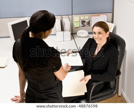 Businesswoman handing co-worker file folder