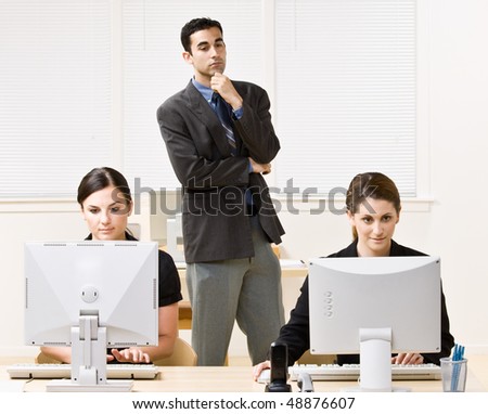 Businessman watching co-workers work