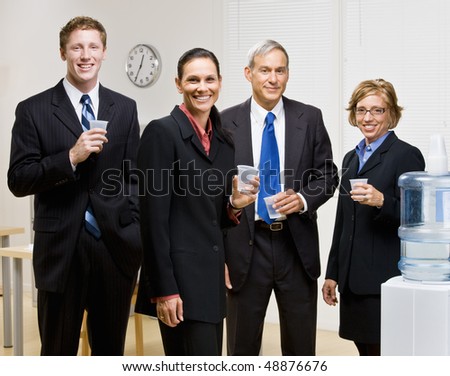 Business people drinking water at water cooler