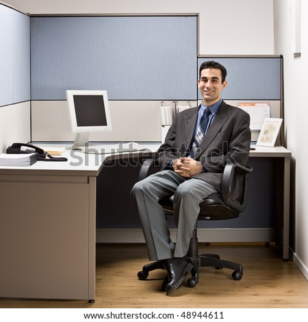 Businessman sitting at desk in cubicle