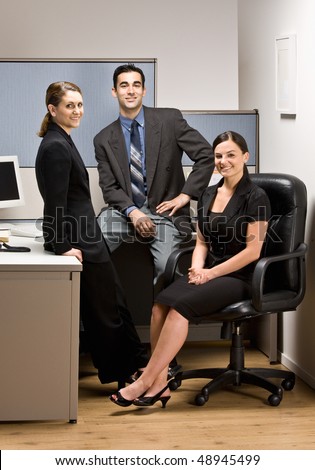 Co-workers sitting in office cubicle