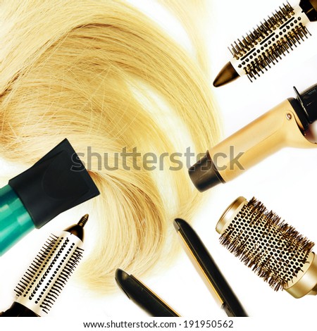 Comb brushes and hairdryer with blond hair.