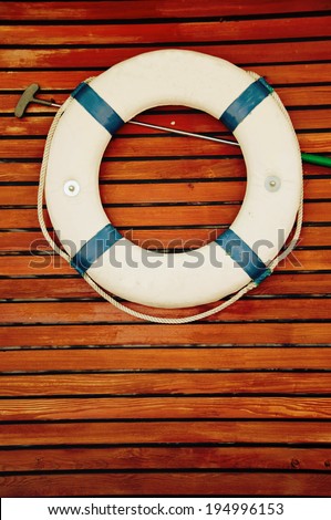 Life buoy hanging on the side of a wooden ship