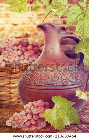 Ceramic jug and grapes on the table. Wine concept.