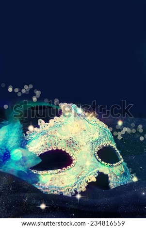 Carnival mask on black silk background.