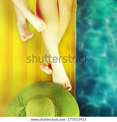Feet of child and mom on the swimming mattress. Vacation background.