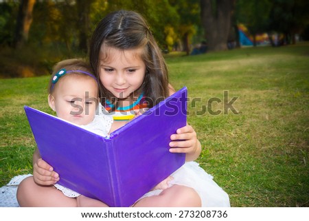 Sisters learning a book outdoor