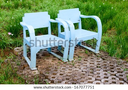 Blue wooden lawn chairs in the spring garden.