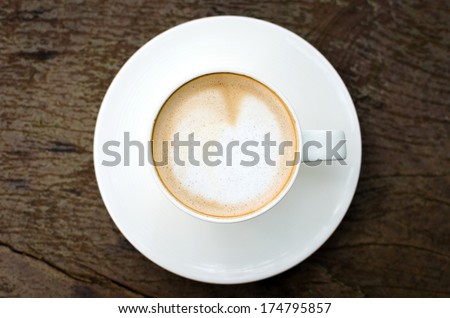 Cup of coffee on wooden table, bird eye view.