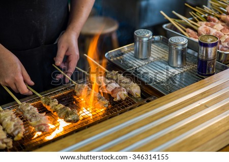Traditional yakitori chicken stand in Japan at street food vendor market, grilled satay. Japanese Food.