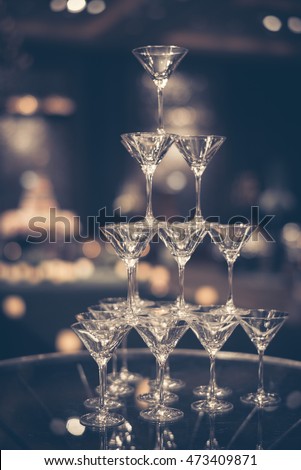 Glass of champagne for event party or wedding ceremony. Pyramid of glasses of champagne for celebrate in party with bokeh background. champagne tower. Process in Vintage Style.