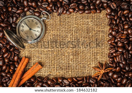 Coffe frame made of beans on burlap with star anise, cinnamon and retro watch