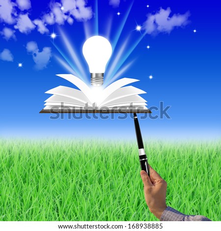 Students holding pen open book with a light bulb idea.