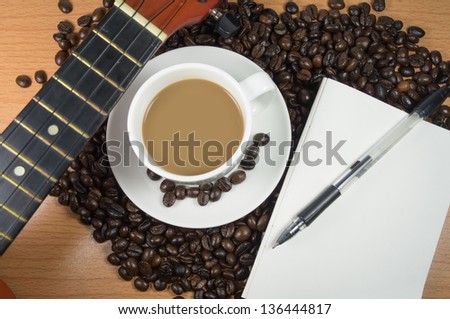 Mocha coffee in white cup with guitar and paper