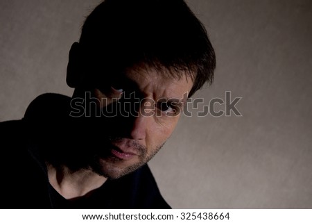 Distraught Man With face In Shadow