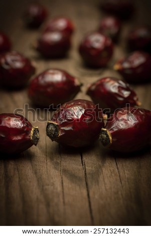 Close up of dried fruits rose hips on a wooden background