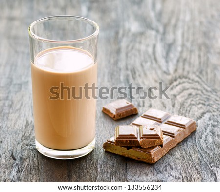 Chocolate milk and chocolate on dark wooden table.