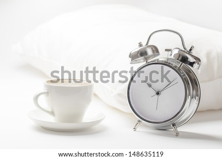Cup of coffe and alarm clock.