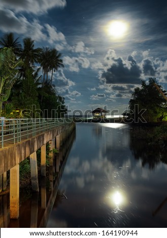 Gazebo and moon in water\'s reflection. Night landscape.