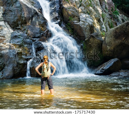 Female hiker looking at waterfall.